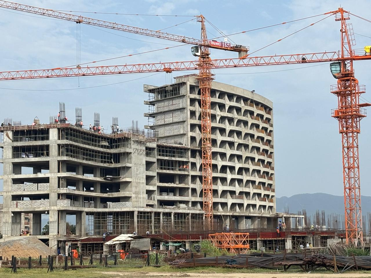 Tower cranes above the emerging curved residential structure